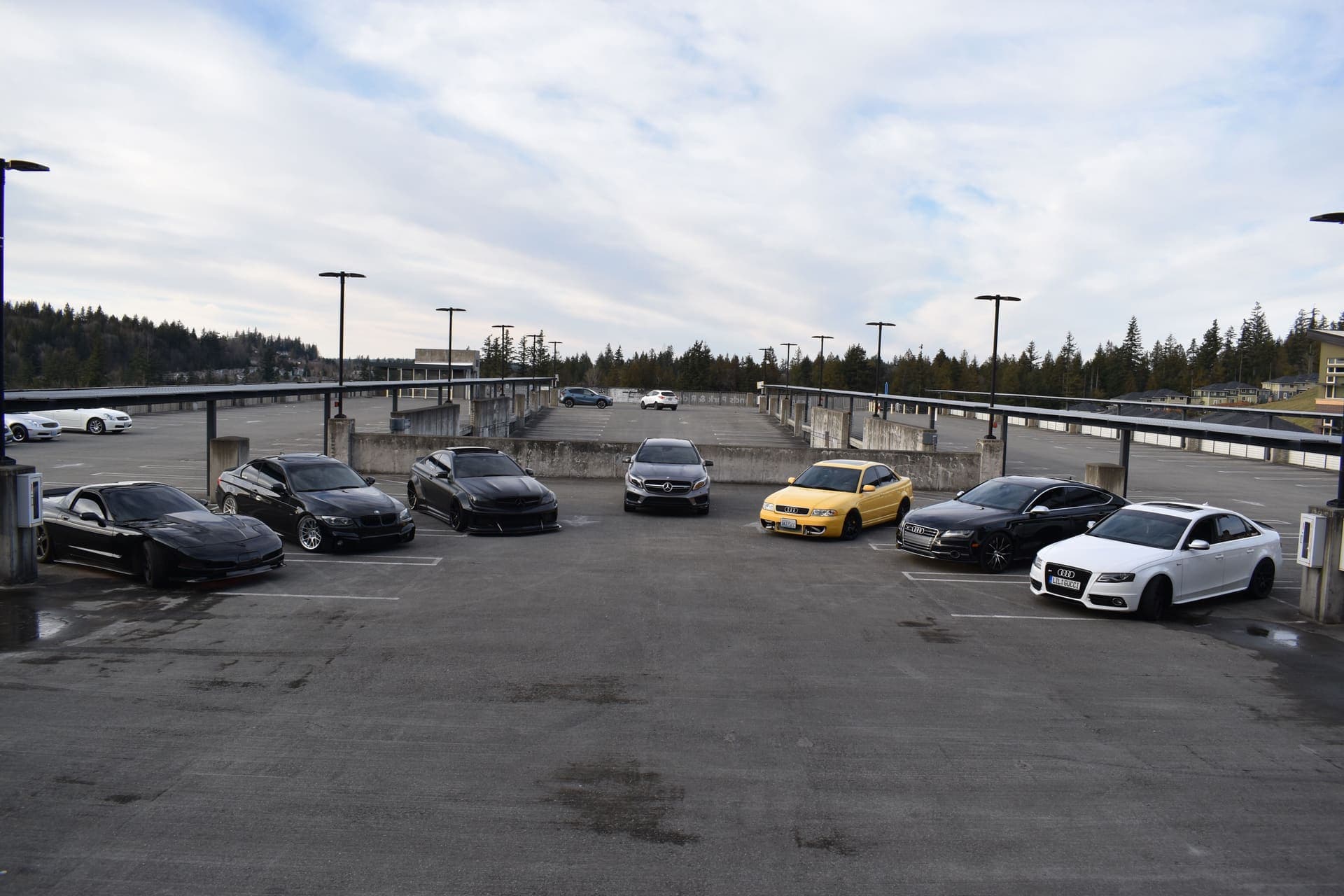 The Northwest Motor Club fleet arced across a Bellevue parking-garage rooftop under Pacific Northwest overcast